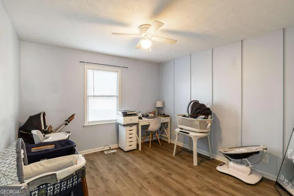 a work room with furniture wooden floor and a window