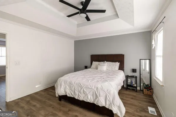 a bedroom with a bed and wooden floor