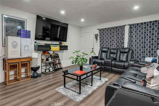 a living room with furniture a flat screen tv and kitchen view