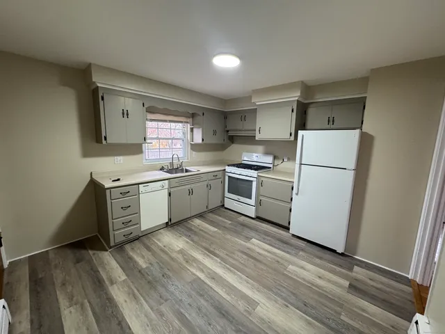 a kitchen with white cabinets and white appliances