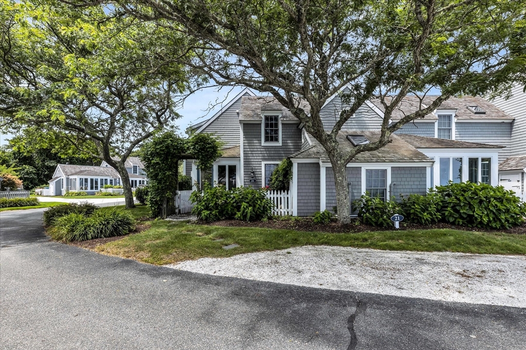 21 Milestone Way, Unit 620 Mashpee, MA 02649 - Photo 3 of 28 a front view of a house with a yard and a garage