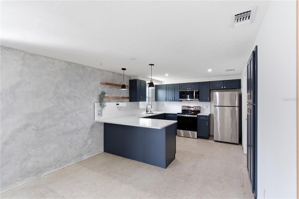 3922 Darlington Road Holiday, FL 34691 - Photo 17 of 30 a kitchen with stainless steel appliances a sink stove and refrigerator