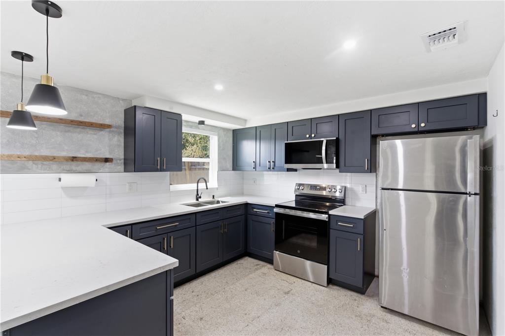 3922 Darlington Road Holiday, FL 34691 - Photo 18 of 30 a kitchen with stainless steel appliances a sink stove and refrigerator