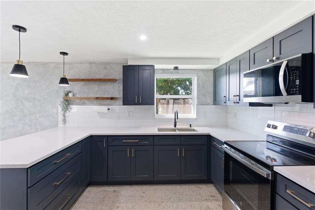3922 Darlington Road Holiday, FL 34691 - Photo 19 of 30 a kitchen with a sink stove and microwave