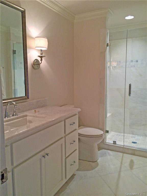 3003 Clarendon Road, Unit A Charlotte, NC 28211 - Photo 11 of 13 a bathroom with a double vanity sink toilet and shower