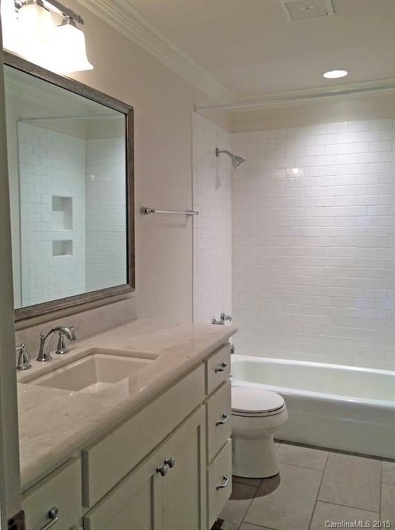 3003 Clarendon Road, Unit A Charlotte, NC 28211 - Photo 13 of 13 a bathroom with a granite countertop toilet a sink and a mirror