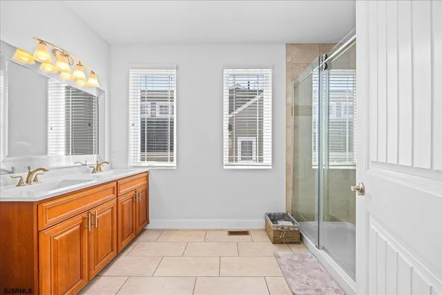 a spacious bathroom with double vanity and a mirror