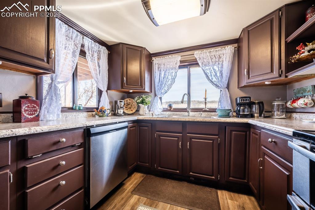8419 3 R Road Beulah, CO 81023 - Photo 26 of 35 a kitchen with stainless steel appliances granite countertop wooden cabinets a sink and dishwasher with wooden floor