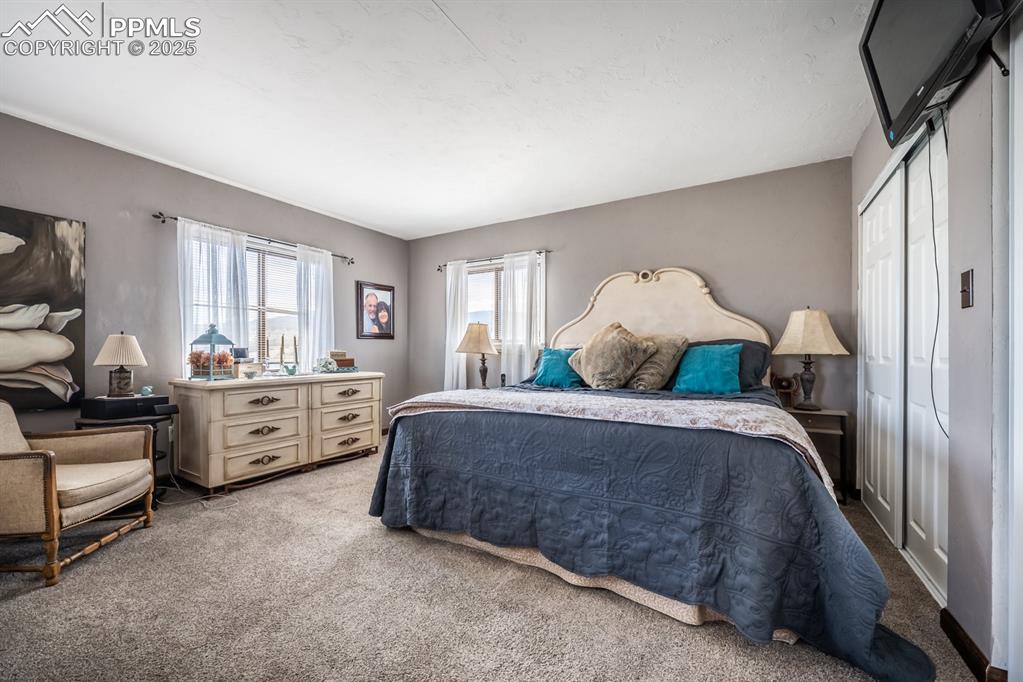 8419 3 R Road Beulah, CO 81023 - Photo 27 of 35 a spacious bedroom with a bed and a chandelier