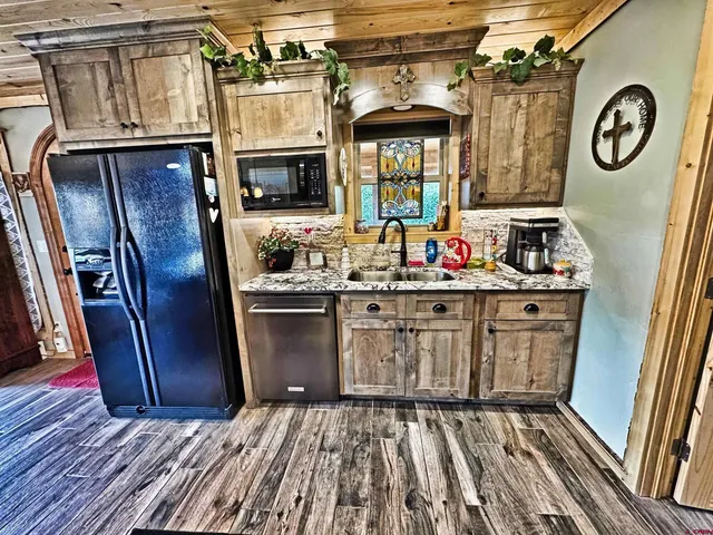 a kitchen with stainless steel appliances granite countertop a refrigerator a stove a sink and dishwasher