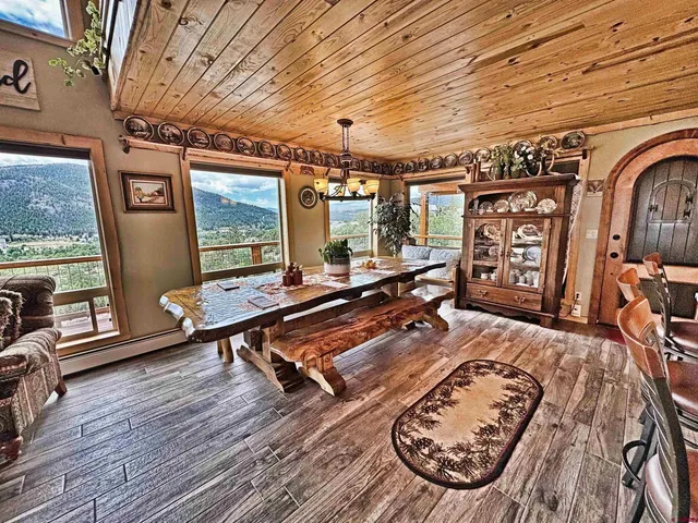a living room with furniture pool table flat screen tv and windows