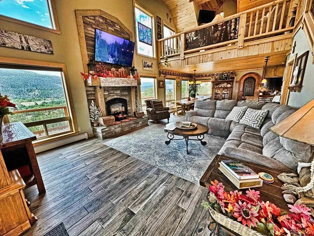 a living room with furniture a fireplace and a floor to ceiling window