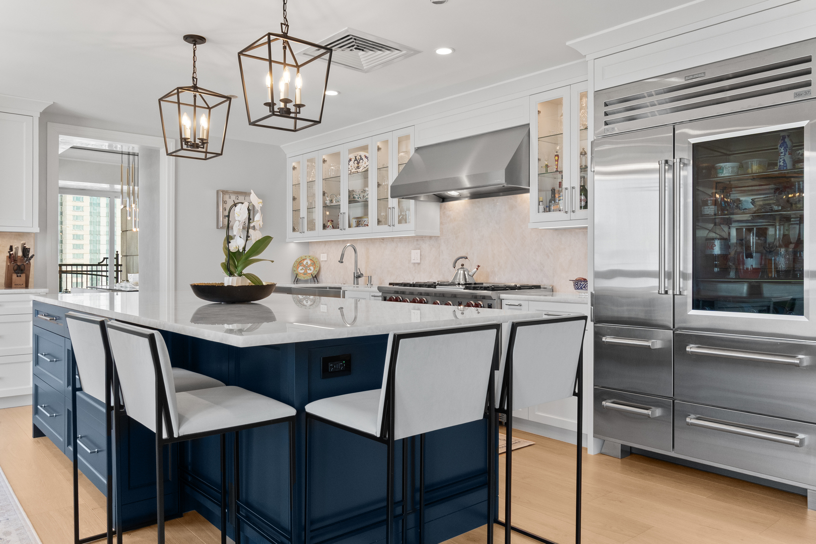 11 East Walton Street, Unit 4802 Chicago, IL 60611 - Photo 15 of 47 a kitchen with stainless steel appliances kitchen island granite countertop a table chairs in it and wooden floors