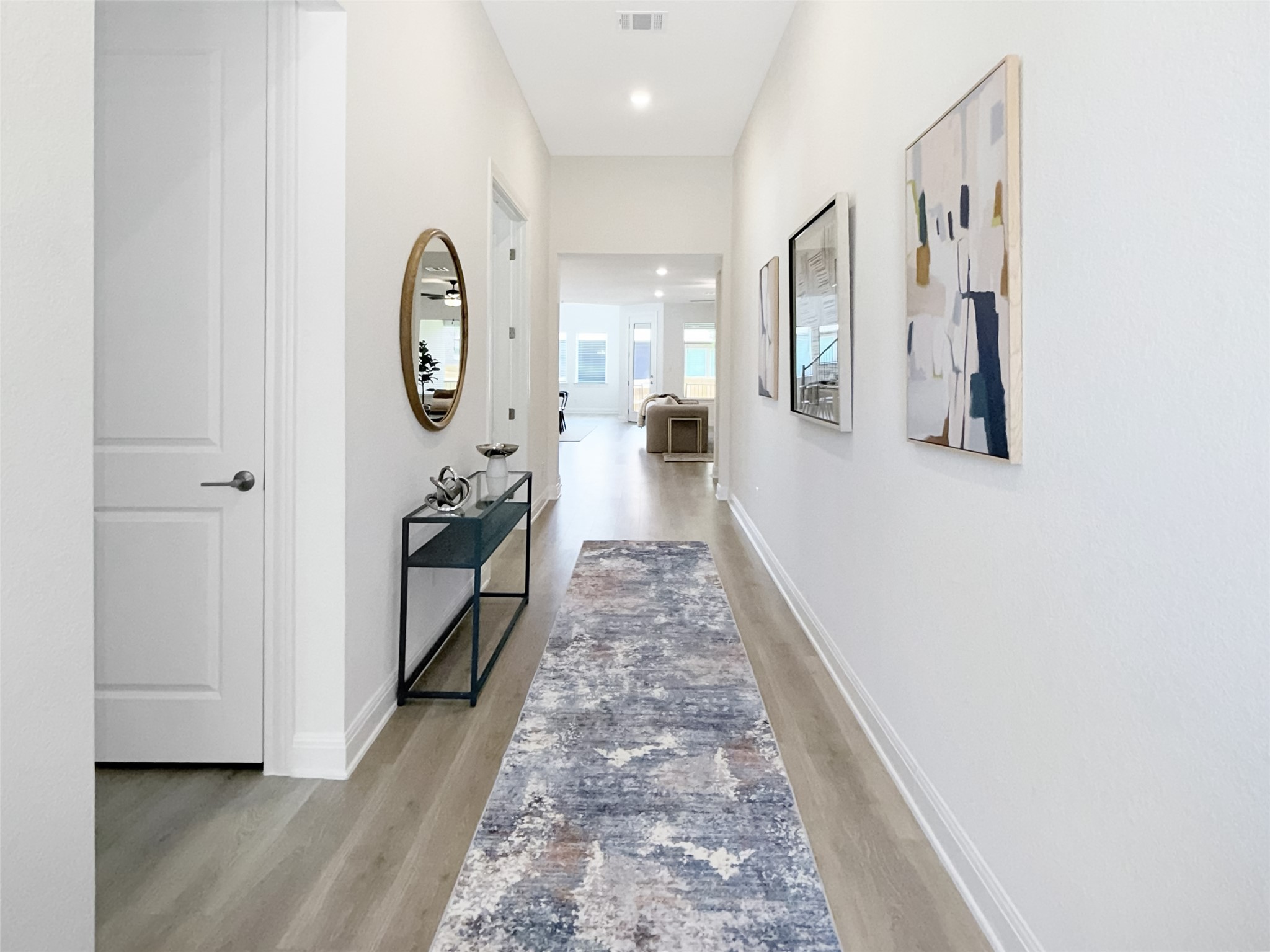 693 Jackson River Loop Kyle, TX 78640 - Photo 4 of 40 a view of a hallway with entryway wooden floor and front door