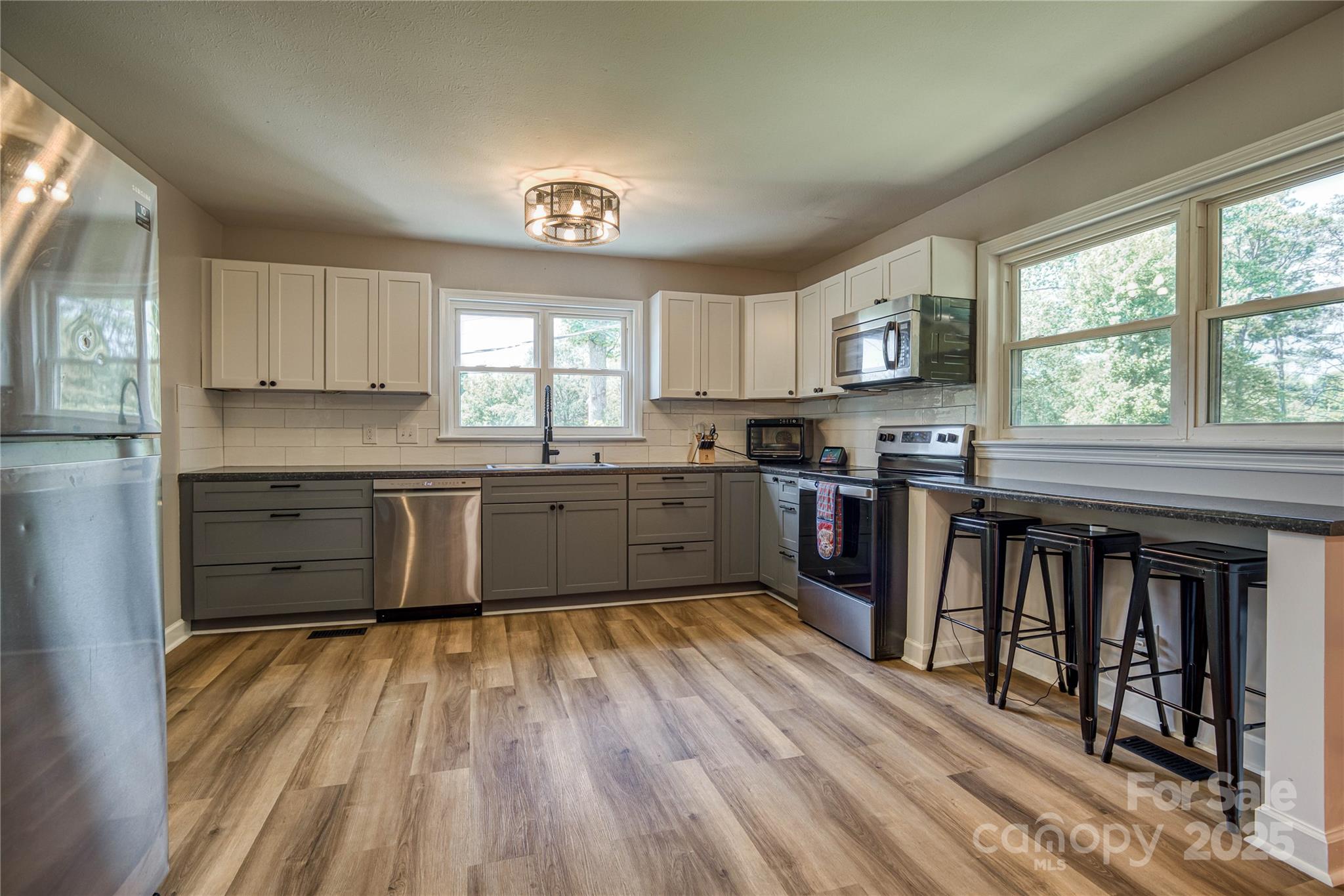 111 Baxter Street Morganton, NC 28655 - Photo 4 of 26 a kitchen with kitchen island granite countertop a stove top oven sink and cabinets