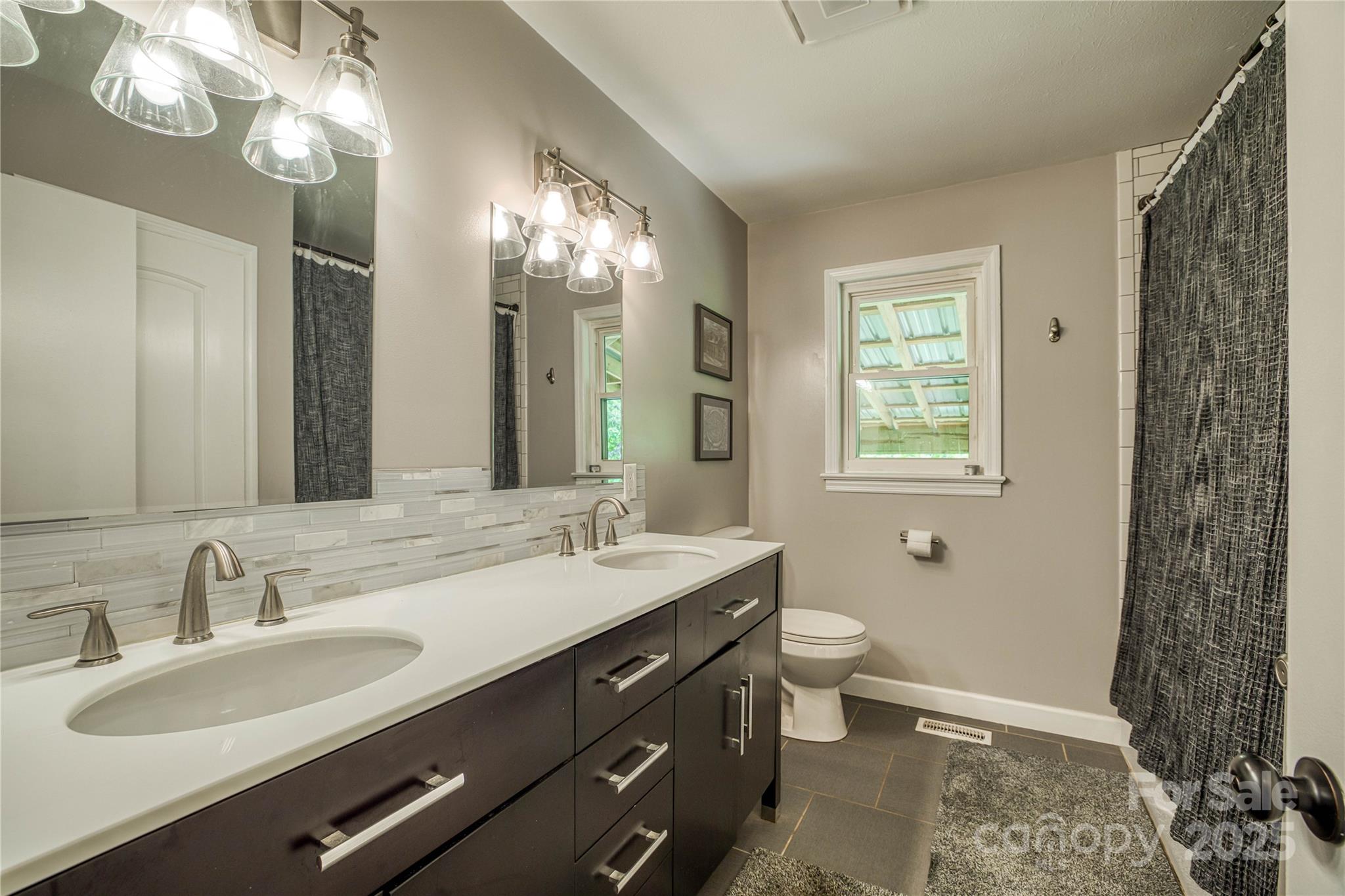 111 Baxter Street Morganton, NC 28655 - Photo 7 of 26 a bathroom with a double vanity sink and a mirror