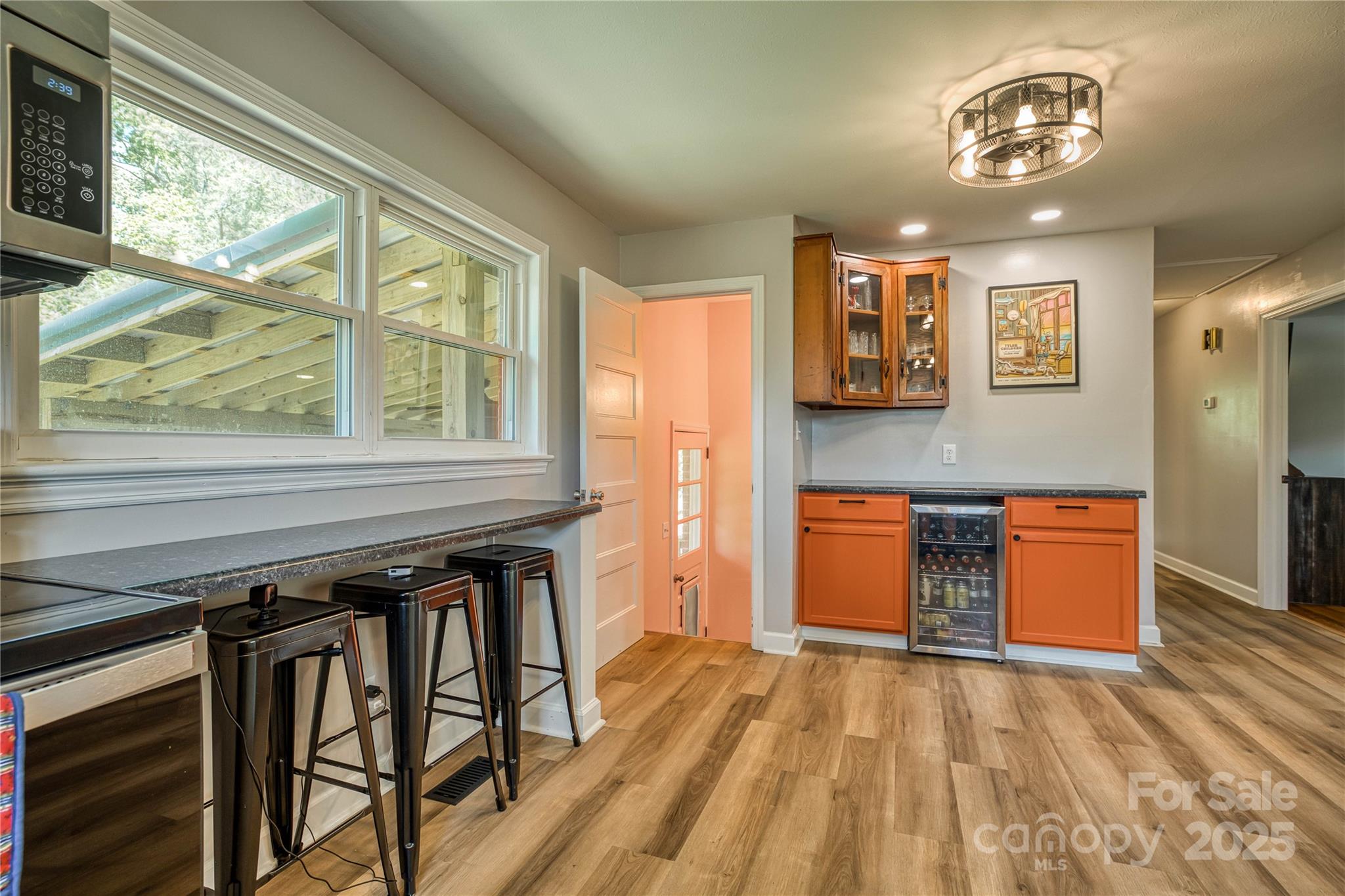 111 Baxter Street Morganton, NC 28655 - Photo 10 of 26 a kitchen with stainless steel appliances granite countertop a stove top oven a refrigerator a dining table and chairs with wooden floor