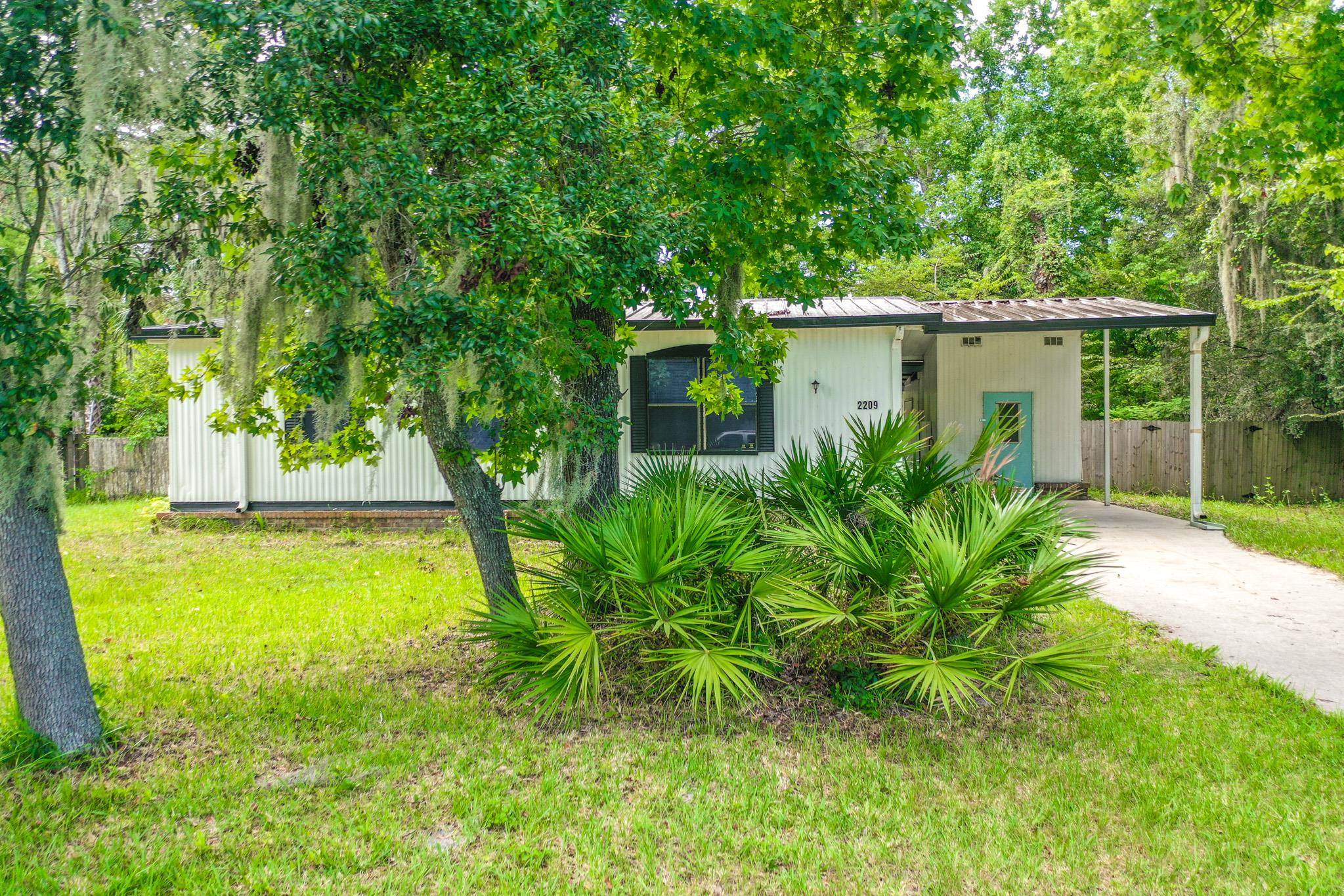 2209 Twin Fox Trail St. Augustine, FL 32086 - Photo 32 of 39 a view of a yard with plants and a large tree