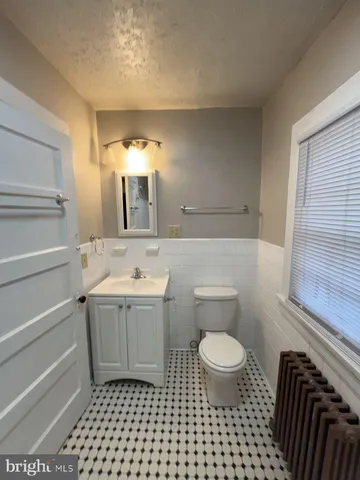a bathroom with a sink a toilet and a mirror