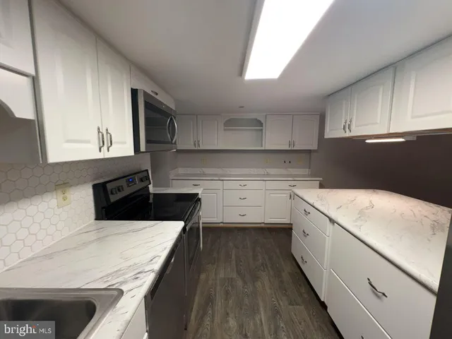 a kitchen with a sink a stove and cabinets