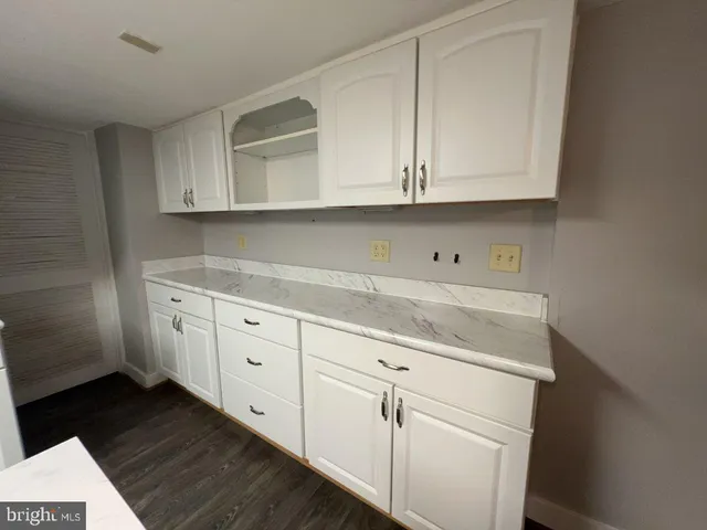 a kitchen with white cabinets and white appliances