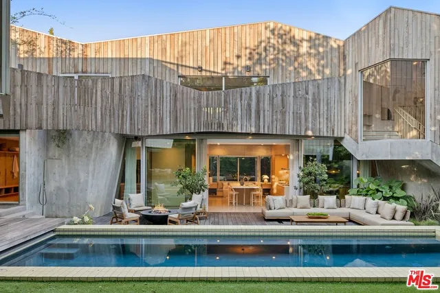 a view of a patio with couches table and chairs and potted plants