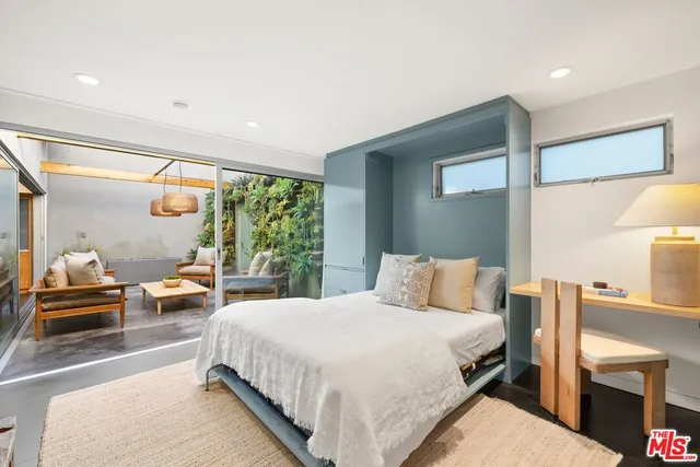 a living room with furniture wooden floor and a floor to ceiling window