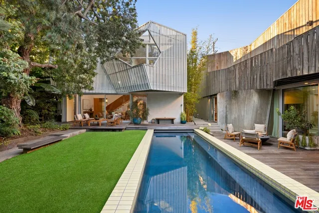 a kitchen with kitchen island a large counter top space a sink stainless steel appliances and windows