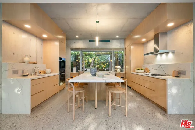 a kitchen with stainless steel appliances granite countertop a sink a stove and a wooden floors