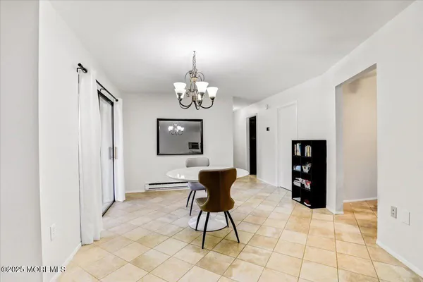 a dining room with chandelier and glass door
