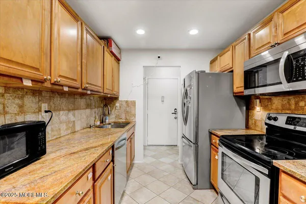 a kitchen with stainless steel appliances a stove a sink and a microwave