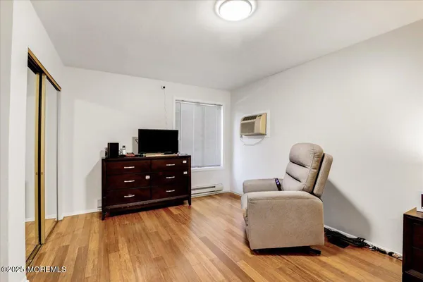 a bedroom with two beds and wooden floor