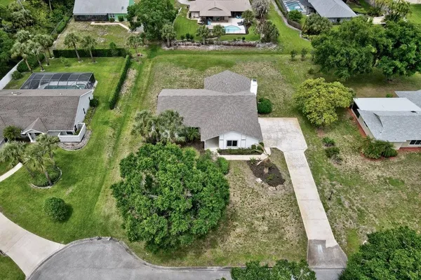 an aerial view of a house with a garden and lake view