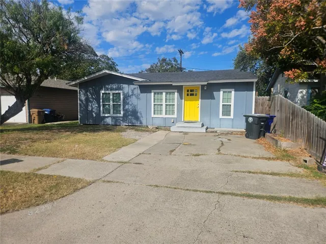 a front view of house with yard and trees in the background
