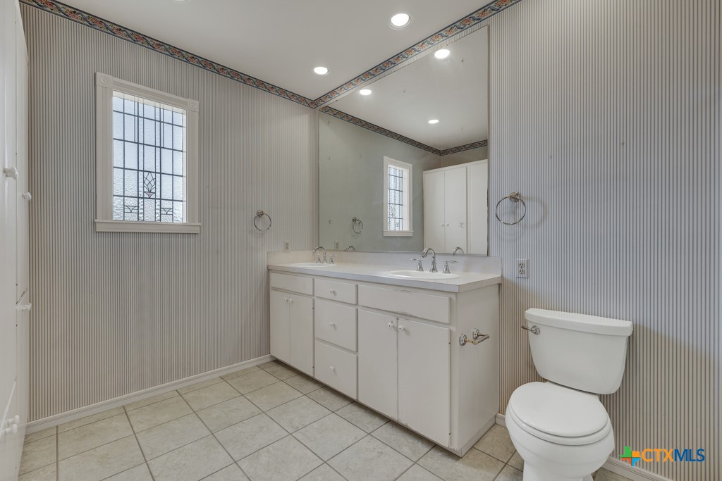 82 Bell Mountain Road Willow City, TX 78675 - Photo 21 of 41 a bathroom with a toilet sink and mirror