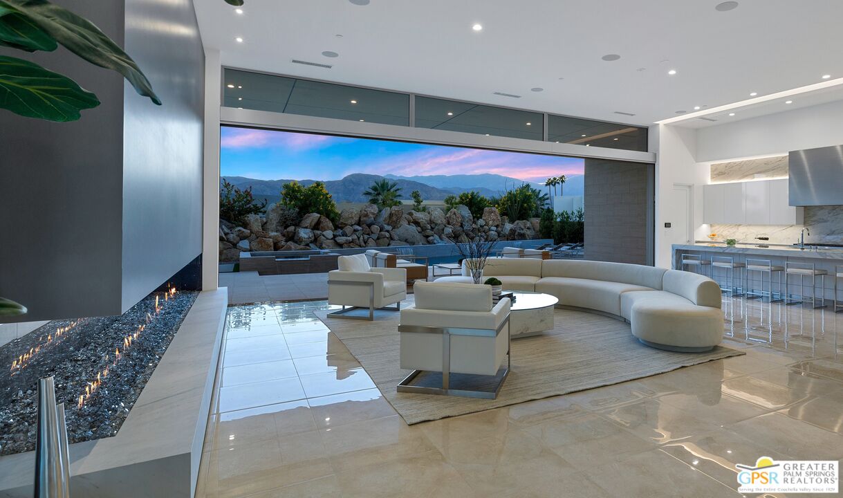 11 Sterling Ridge Drive Rancho Mirage, CA 92270 - Photo 3 of 33 a living room with couches bookshelf and a large window with garden view