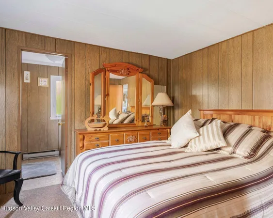 a bedroom with a bed and a large mirror