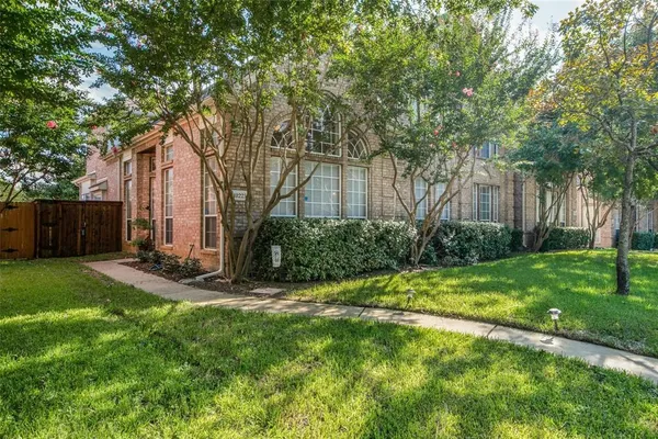 a view of a backyard with table and chairs and a large tree