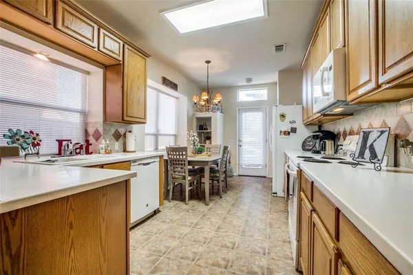 a kitchen with kitchen island granite countertop a sink stove and cabinets