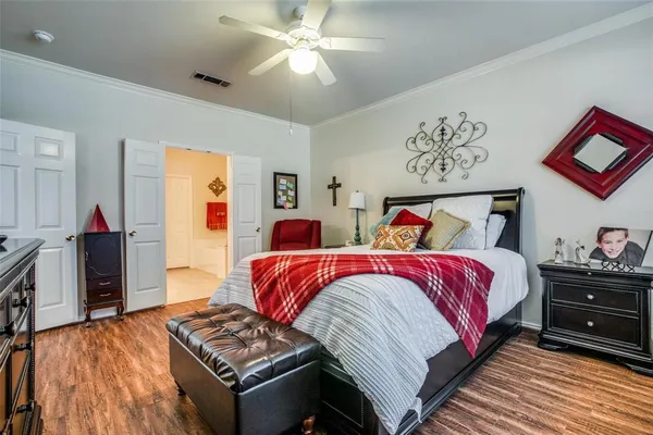 a bedroom with bed and wooden floor