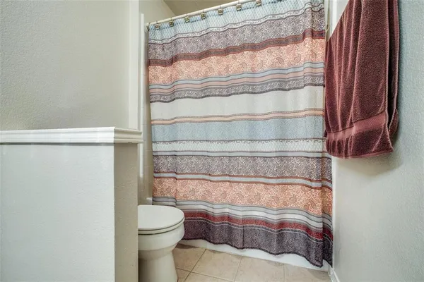 a bathroom with a toilet and a shower curtain
