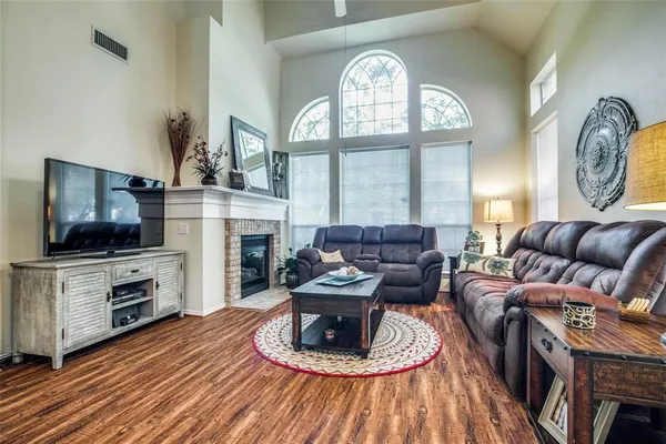 a living room with furniture a fireplace a flat screen tv and a large window