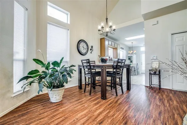 a view of a dining room and livingroom with furniture wooden floor and a clock