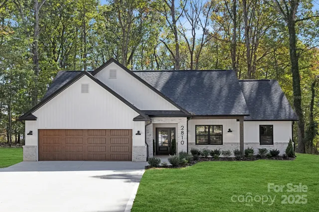 a front view of a house with a garden and yard