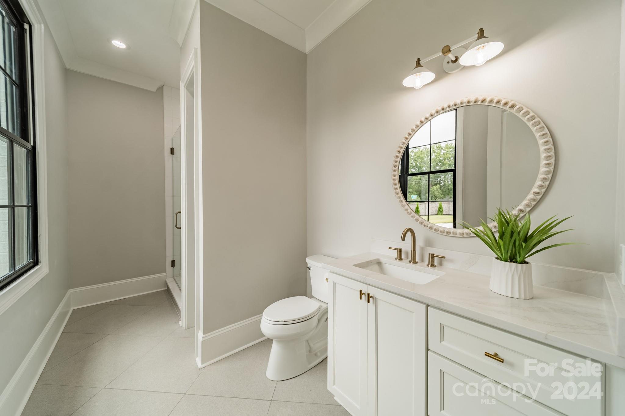 4428 Carmel Road Charlotte, NC 28226 - Photo 26 of 48 a bathroom with a toilet sink and mirror