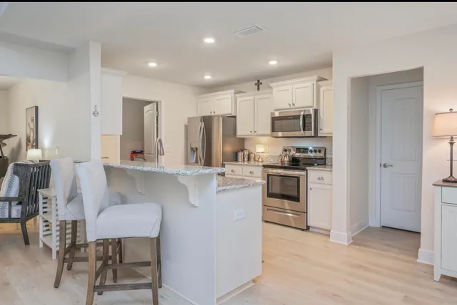 a kitchen with stainless steel appliances a stove a sink refrigerator and a microwave