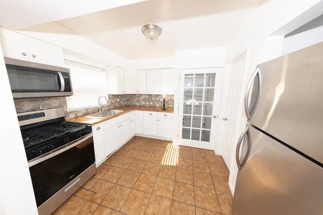 a kitchen with stainless steel appliances a refrigerator and a stove top oven
