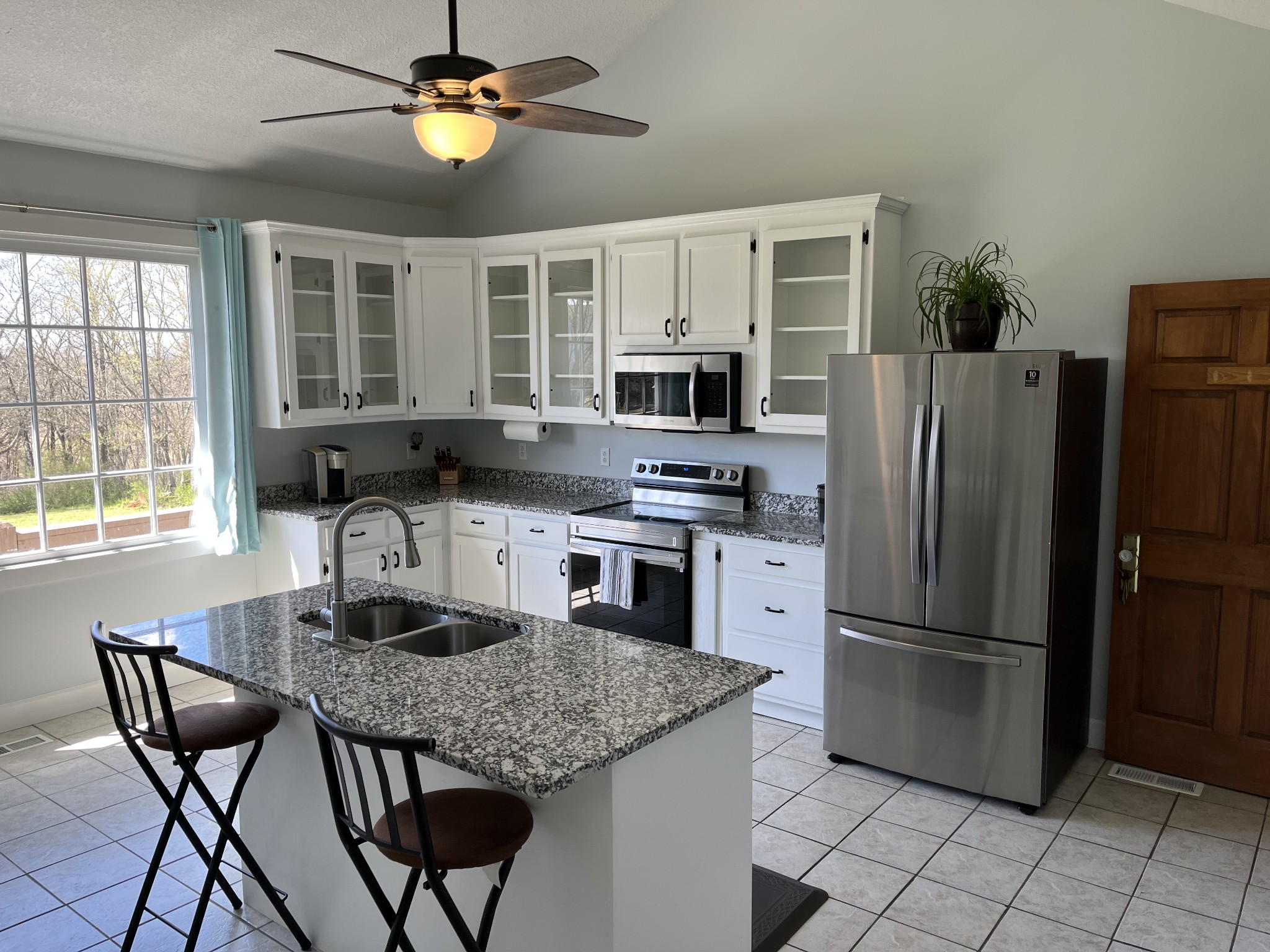 1282 East Roarks Cove Road Decherd, TN 37324 - Photo 7 of 24 a kitchen with granite countertop a table chairs microwave and refrigerator