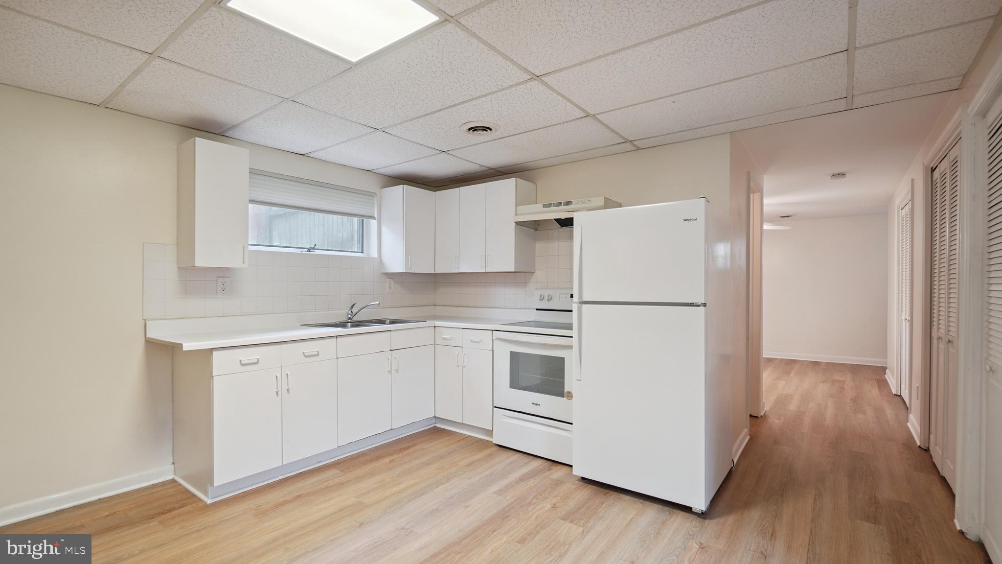 1718 Quantico Road Edgewater, MD 21037 - Photo 40 of 54 a kitchen with cabinets appliances wooden floor and a window