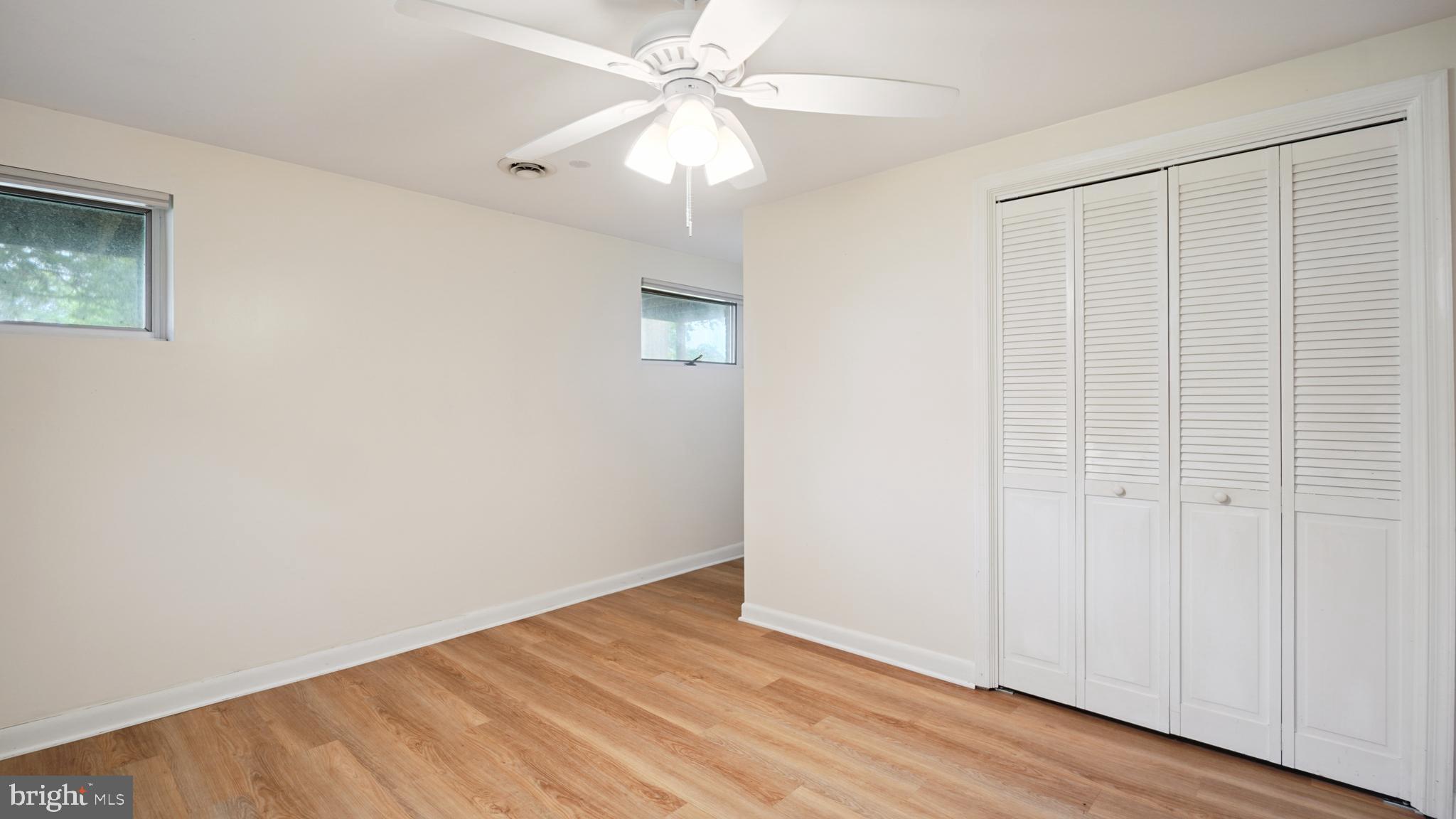 1718 Quantico Road Edgewater, MD 21037 - Photo 47 of 54 an empty room with wooden floor chandelier fan and windows